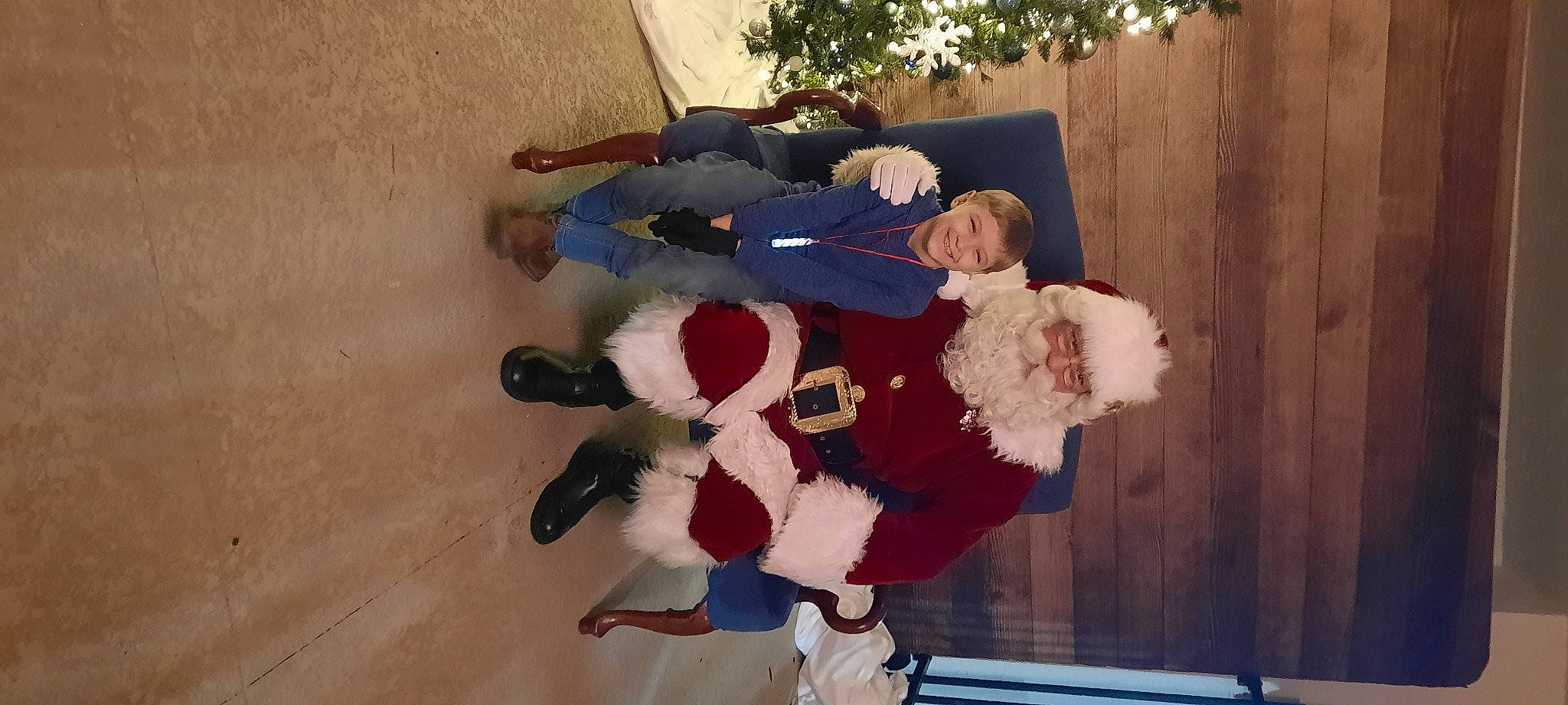 Ezekiel joined the competition — help win amazing prizes! carmine, christmas, costume, event, fictional_character, flooring, fun, fur, fur_clothing, holiday, human_leg, joy, knee, lap, person, plant, room, santa_claus, sock, thigh