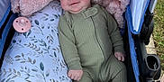 Baylee is registered to the contest to win money with this photo: baby, infant, onesie, stroller, blanket, pillow, pacifier, outdoor, grass, happy, smiling, face, person, child, soft_texture, blue, pink, pattern, comfort, relaxed