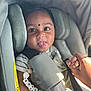 baby, child, car_seat, seatbelt, holding_hands, tongue_out, cute, infant, person, safety, accessory, beads, clothing, striped_shirt, closeup, portrait, smile, hand, infant_seat, sunlight