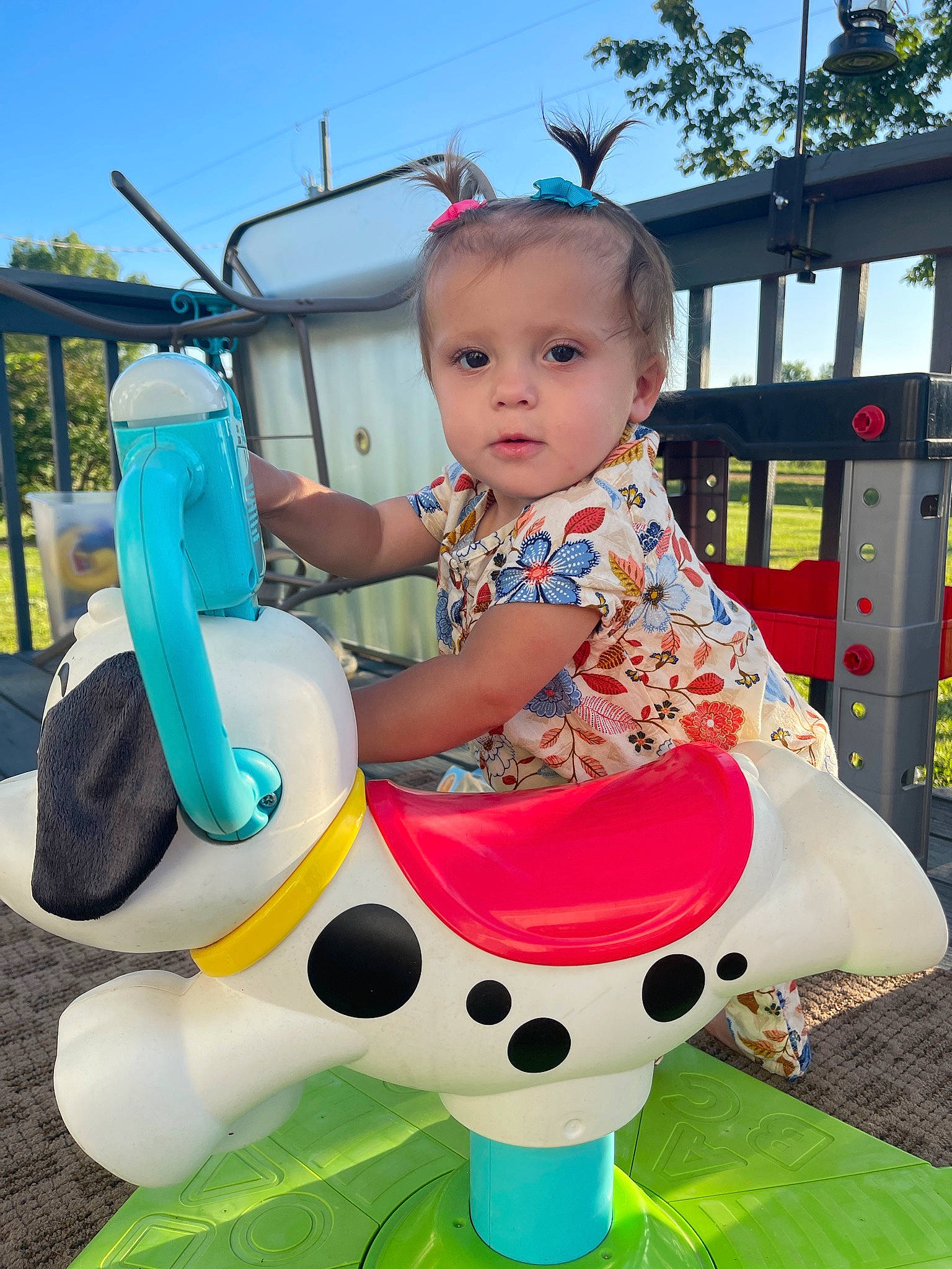 Scotlyn is registered to the contest to win money with this photo: baby, baby_toddler_clothing, blue, child, city, fun, grass, green, happy, leisure, outdoor_play_equipment, person, pink, play, playground, product, recreation, sitting, sky, toddler