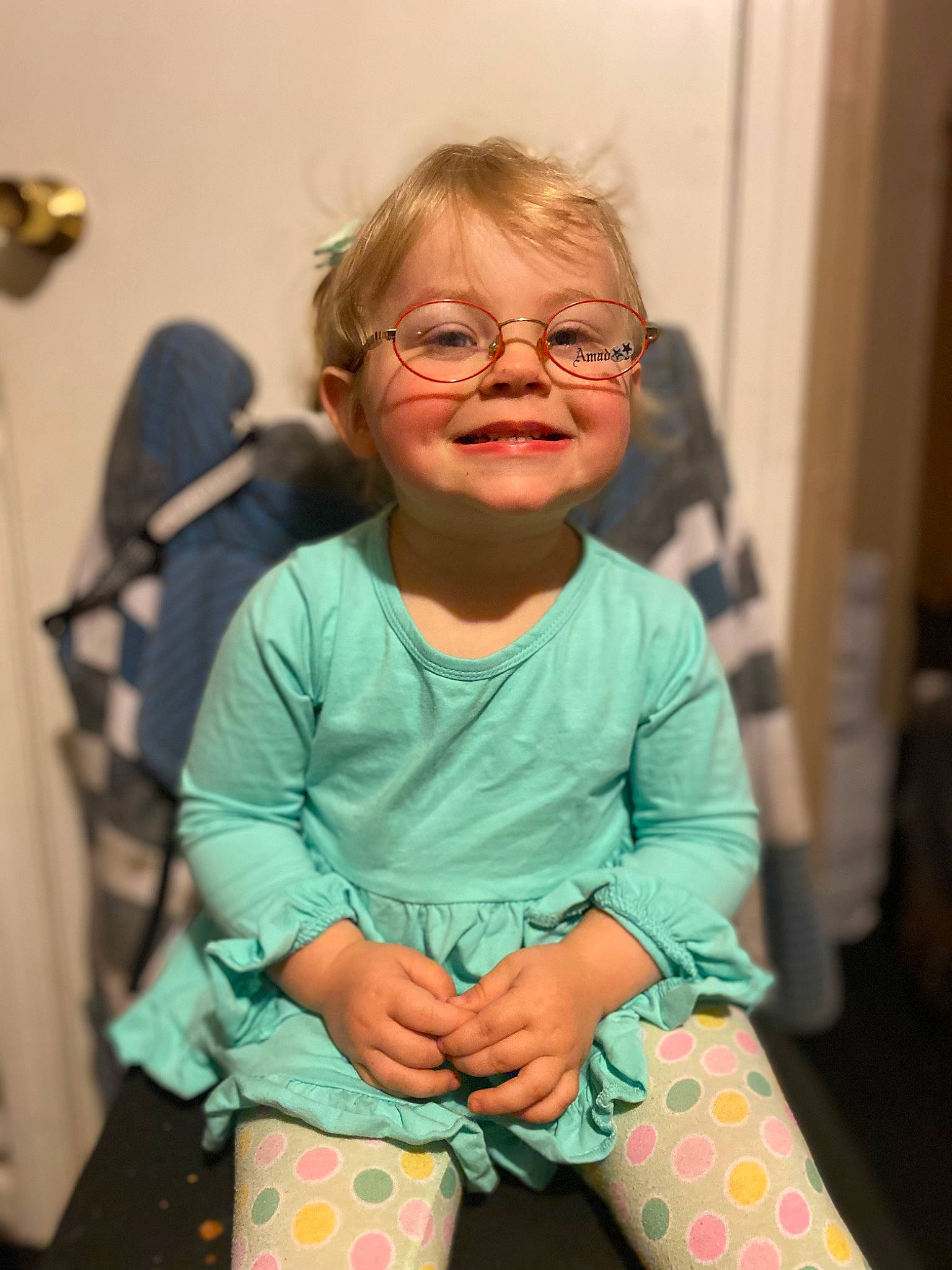 Sophie is registered to the contest to win money with this photo: baby_toddler_clothing, cheek, child, dress, event, eyewear, fun, glasses, happy, head, joy, pattern, person, sitting, skin, sleeve, smile, sock, t_shirt, thigh