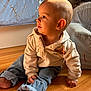 toddler, child, baby, hoodie, jeans, floor, wooden_floor, indoor, portrait, sitting, barefoot, face, curious, light, shadow, clothing, person, home, furniture, cozy