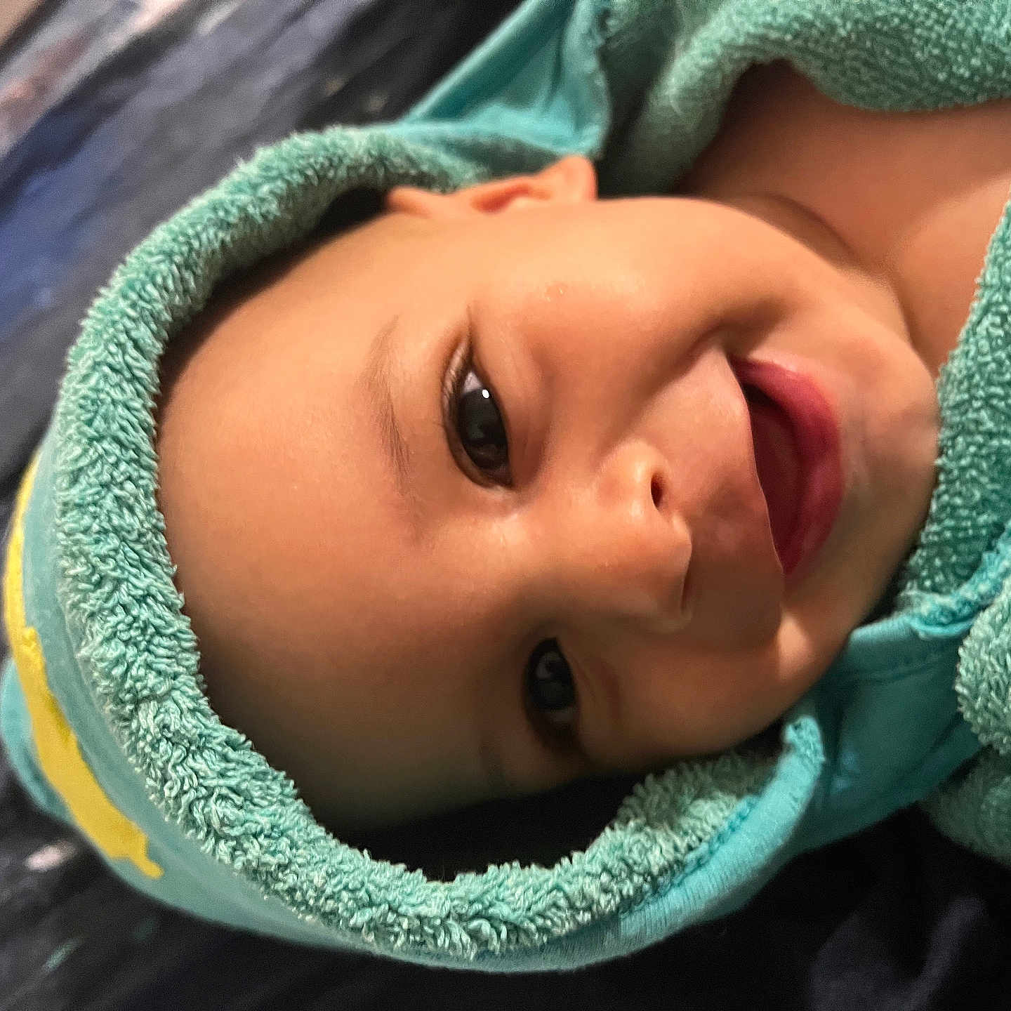 Ayoub participe au concours pour gagner de l'argent avec cette photo : baby, blue_towel, child, close_up, cozy, cute, eyes, face, happy, hood, indoors, infant, lying_down, mouth, portrait, skin, smiling, soft_texture, towel, young_child