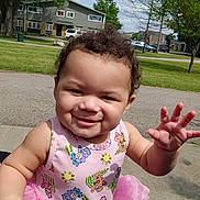 Ryder is registered to the contest to win money with this photo: toddler, child, smiling, outdoor, park, greenery, tree, dress, colorful_clothing, curly_hair, playful, sunny_day, sidewalk, blue_object, happy, person, summer, nature, baby, daylight