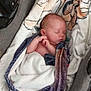 Lexy participe au concours pour gagner de l'argent avec cette photo : baby, newborn, sleeping, blanket, stroller, cushion, infant, wrapped, peaceful, child, soft_texture, resting, cute, indoors, portrait, tiny_feet, head, skin, peace, comfort