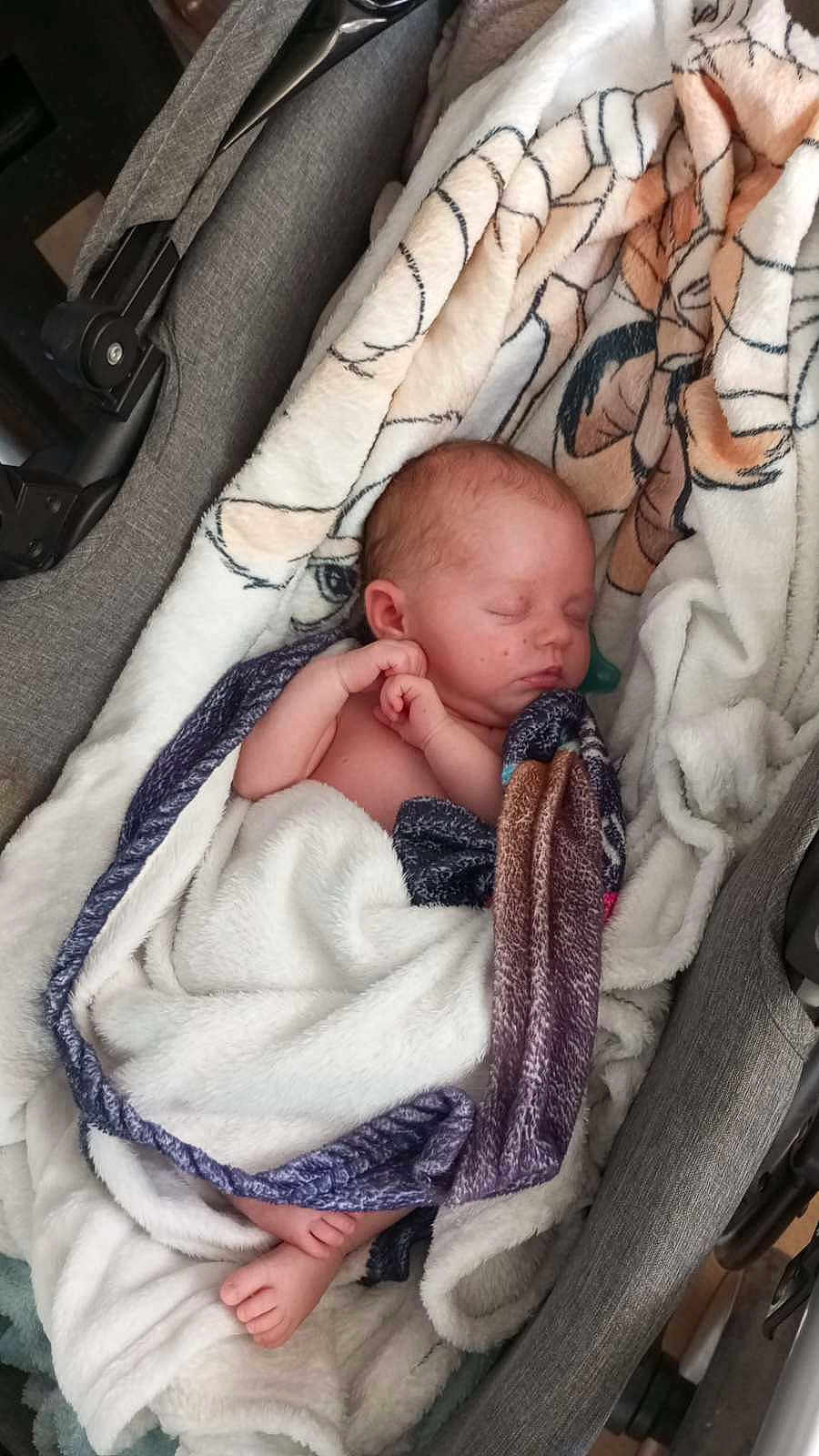 Lexy participe au concours pour gagner de l'argent avec cette photo : baby, newborn, sleeping, blanket, stroller, cushion, infant, wrapped, peaceful, child, soft_texture, resting, cute, indoors, portrait, tiny_feet, head, skin, peace, comfort