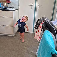 Kurtys participe au concours pour gagner de l'argent avec cette photo : toddler, child, kitchen, floor, cabinet, door, towel, chair, smile, motion, barefoot, clothing, indoors, home, furniture, pot, stove, playful, happy, person