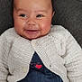 Laïane a rejoint le concours — aidez-le/la à gagner de superbes lots ! baby, infant, smiling, face, white_cardigan, denim, clothing, happy, cute, portrait, child, person, soft_background, cozy, seated, small_hands, close_up, warm, adorable, indoor
