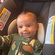 Corey joined the competition — help win amazing prizes! baby, infant, child, car_seat, portrait, smiling, wide_eyed, sitting, camouflage, onesie, clothing, hair, face, indoors, vehicle, safety_strap, car_interior, photography, cute, happy