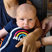 Malo participe au concours pour gagner de l'argent avec cette photo : baby, child, mickey_mouse, onesie, person, arm, hand, clothing, indoor, portrait, serious_face, holding, casual, sitting, skin, colorful, closeup, family, people, caring