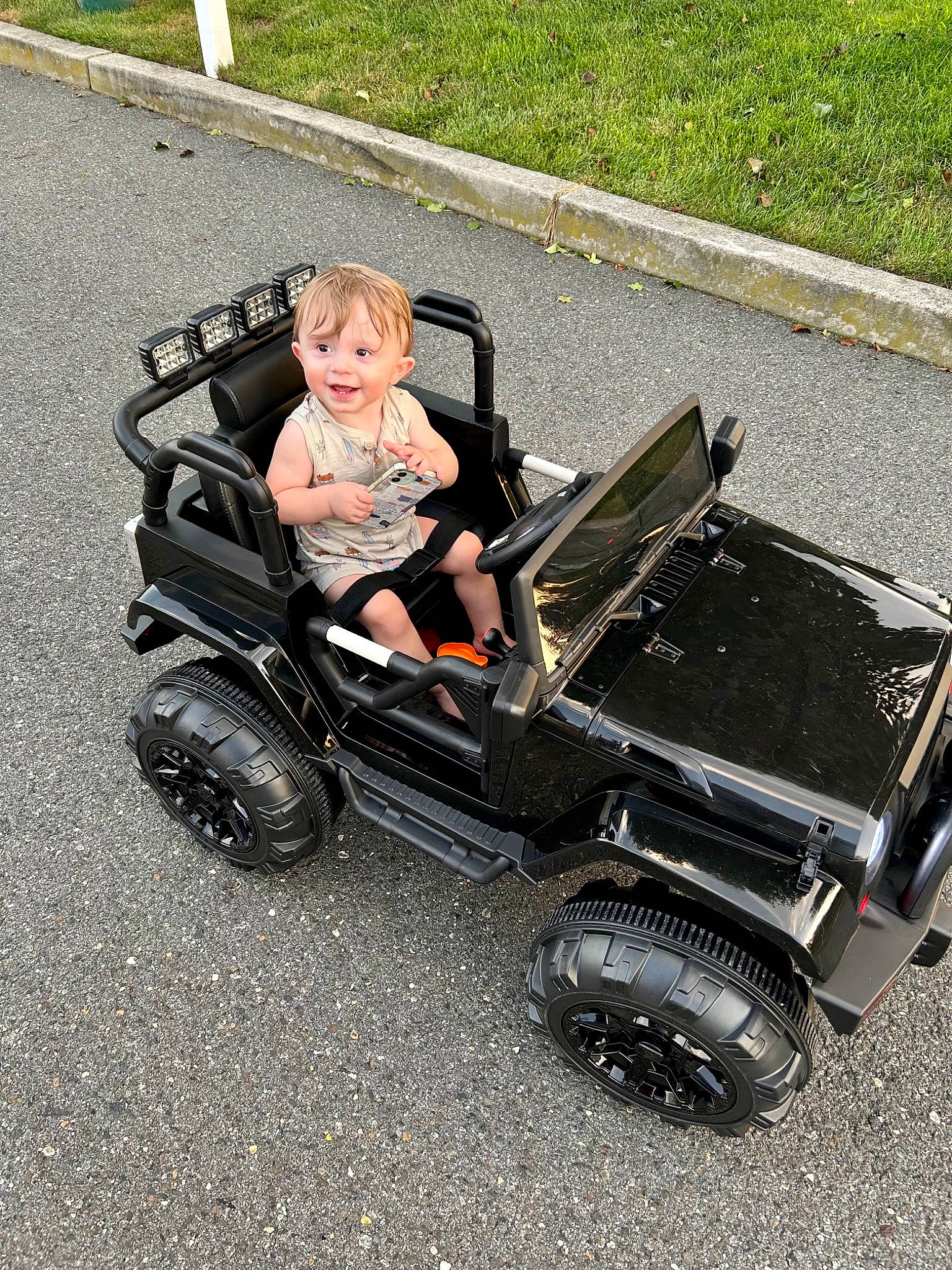 Hunter is registered to the contest to win money with this photo: auto_part, automotive_design, automotive_exterior, automotive_tire, automotive_wheel_system, bumper, car, fender, joy, lawn, motor_vehicle, person, riding_toy, rim, rolling, synthetic_rubber, tire, toddler, toy, tread