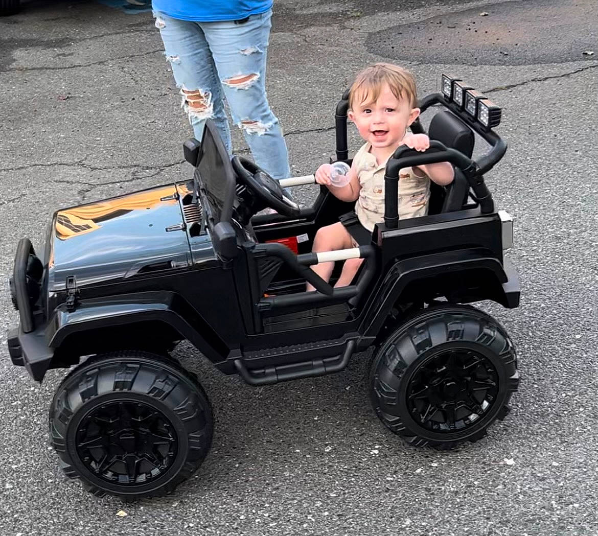 Hunter is registered to the contest to win money with this photo: auto_part, automotive_design, automotive_exterior, automotive_tire, automotive_wheel_system, bumper, car, fender, locking_hubs, motor_vehicle, person, rim, rolling, smile, synthetic_rubber, tire, tire_care, toddler, tread, vehicle