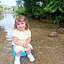 child, toddler, water, creek, nature, outdoor, trees, wet_hair, yellow_dress, bucket, smile, sandals, rocks, people, playing, summer, daylight, grass, relaxation, river
