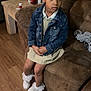 Alaia is registered to the contest to win money with this photo: child, girl, denim_jacket, dress, bow, curly_hair, couch, living_room, wooden_floor, side_table, socks, white_shoes, sitting, indoor, thoughtful, furniture, casual_clothing, home, person, portrait