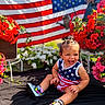 Nova Ann joined the competition — help win amazing prizes! toddler, child, smiling, american_flag, flowers, outdoor, summer, happy, grass, plants, pigtails, sneakers, red_flowers, pink_flowers, white_flowers, colorful, nature, celebration, portrait, casual_clothing