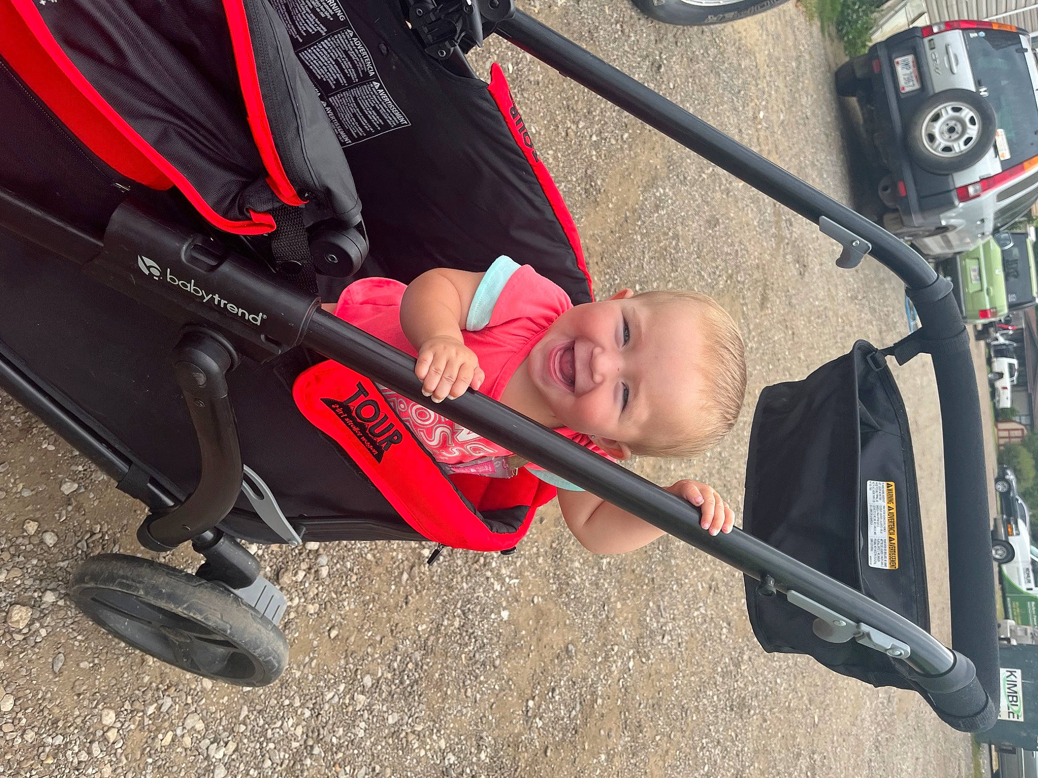 Harper is registered to the contest to win money with this photo: auto_part, automotive_exterior, automotive_tire, automotive_wheel_system, baby_carriage, baby_products, car, carmine, comfort, fender, joy, motor_vehicle, person, shoe, smile, sneakers, street_light, tire, toddler, tree