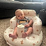 Silviano joined the competition — help win amazing prizes! baby, infant, child, puma_clothing, onesie, inflatable_chair, teddy_bear_pattern, carpet, sofa, couch, living_room, indoor, person, sitting, cute, soft_light, floor, furniture, head, feet