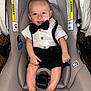 Silviano joined the competition — help win amazing prizes! baby, infant, car_seat, bow_tie, white_shirt, black_shorts, smiling, happy, child, cute, sitting, indoors, clothing, person, seatbelt, footwear_absent, skin, head, face, portrait