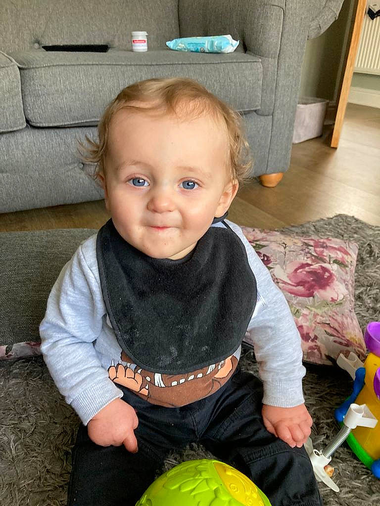 Finley joined the competition — help win amazing prizes! baby, baby_toddler_clothing, cheek, child, couch, dress, eye, face, floor, flooring, fun, green, happy, iris, person, plant, sitting, smile, t_shirt, toddler