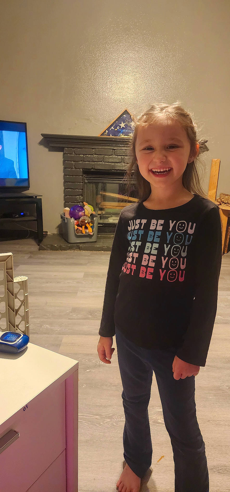 Blakelyn is registered to the contest to win money with this photo: denim, display_device, event, flooring, fun, happy, home_appliance, joy, led_backlit_lcd_display, person, room, shoulder, sleeve, smile, sportswear, t_shirt, television, television_set, toddler, trunk