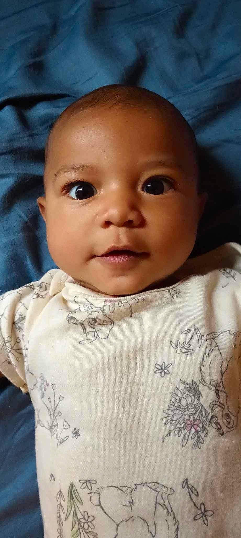 Kiara is registered to the contest to win money with this photo: baby, baby_toddler_clothing, cheek, child, chin, collar, comfort, eye, eyebrow, eyelash, iris, linens, lip, no_expression, nose, pattern, person, skin, sleeve, toddler