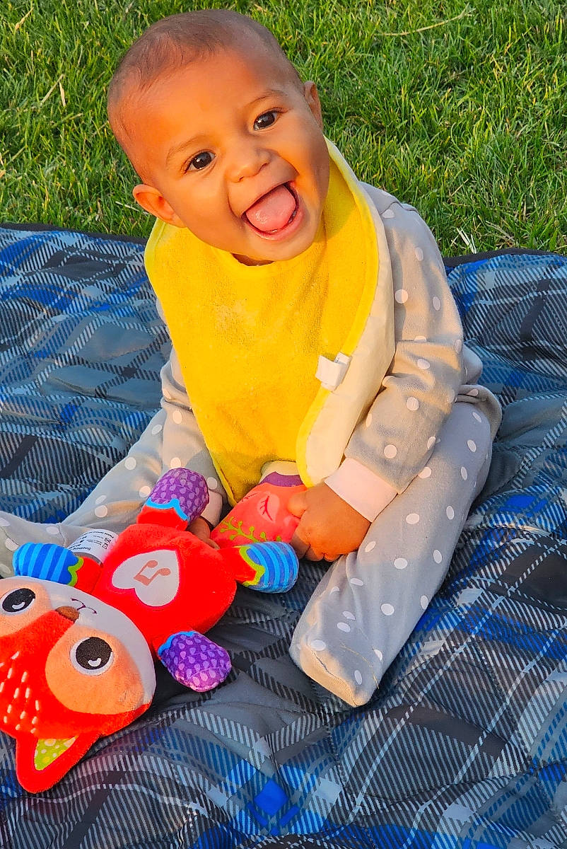 Kiara joined the competition — help win amazing prizes! baby, baby_products, baby_toddler_clothing, blue, child, eye, face, facial_expression, fun, grass, happy, head, leisure, people_in_nature, person, plant, recreation, smile, textile, toddler