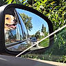 dog, car, side_mirror, window, outdoor, greenery, sunny, reflection, vehicle, road, tree, sky, happy, pet, animal, nature, travel, smiling, daytime, leaves