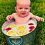 baby, milk_bath, bucket, lemon_slices, strawberries, grass, outdoor, child, smiling, fruit, playful, nature, summer, cute, water, skin, fresh, happy, sitting, fun