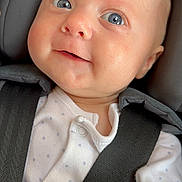 Charlie is registered to the contest to win money with this photo: baby, infant, face, blue_eyes, onesie, car_seat, seatbelt, child, cute, smile, hand, clothing, safety, portrait, closeup, skin, head, person, newborn, baby_girl