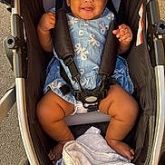 Eleanor joined the competition — help win amazing prizes! baby, stroller, child, smiling, blue_dress, hair_bun, blanket, sitting, outdoor, pavement, safety_harness, infant, cute, happy, person, footwear, black_hair, toddler, baby_clothing, seat