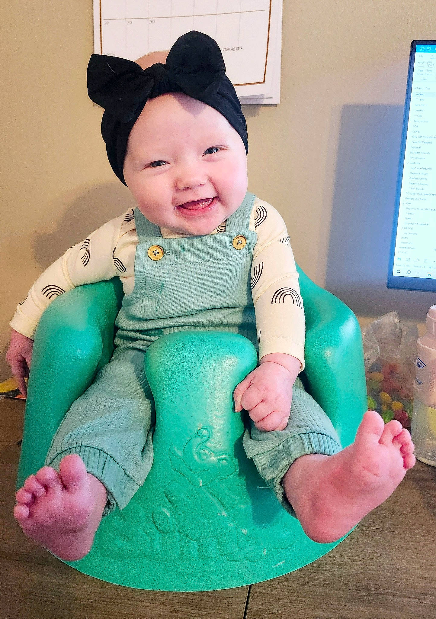 Montana is registered to the contest to win money with this photo: arm, baby, baby_toddler_clothing, child, finger, happy, headgear, headwear, joy, lap, outerwear, person, pink, product, purple, sitting, sleeve, smile, stuffed_toy, television