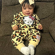 Nova joined the competition — help win amazing prizes! baby, child, infant, leopard_print, hello_kitty, bow, headwear, socks, couch, furniture, smiling, sitting, indoors, cute, portrait, clothing, happy, young_child, person, cozy