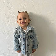 Camélia a rejoint le concours — aidez-le/la à gagner de superbes lots ! toddler, child, smiling, denim_jacket, white_leggings, standing, hair_buns, happy, indoor, wall, texture, portrait, cute, person, fashion, casual, young_child, light, face, clothing