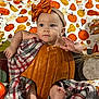 autumn, baby, blanket, child, costume, cute, decorations, fall, festive, flower, foot, headband, holiday, indoor, orange_bow, plush, portrait, pumpkin, seasonal, smiling