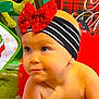 baby, blanket, cheerful, child, colorful, crawling, cute, face, festive, green_lights, headband, holiday_decor, indoors, plaid_pattern, portrait, red_bow, soft_texture, striped_band, toddler, young_child