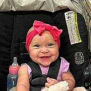 Brytyn is registered to the contest to win money with this photo: baby, baby_toy, blanket, bottle, car_seat, child, closeup, clothing, cute, face, happy, headband, indoor, infant, person, pink_bow, seat, smile, straps, toddler