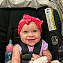 baby, baby_toy, blanket, bottle, car_seat, child, closeup, clothing, cute, face, happy, headband, indoor, infant, person, pink_bow, seat, smile, straps, toddler