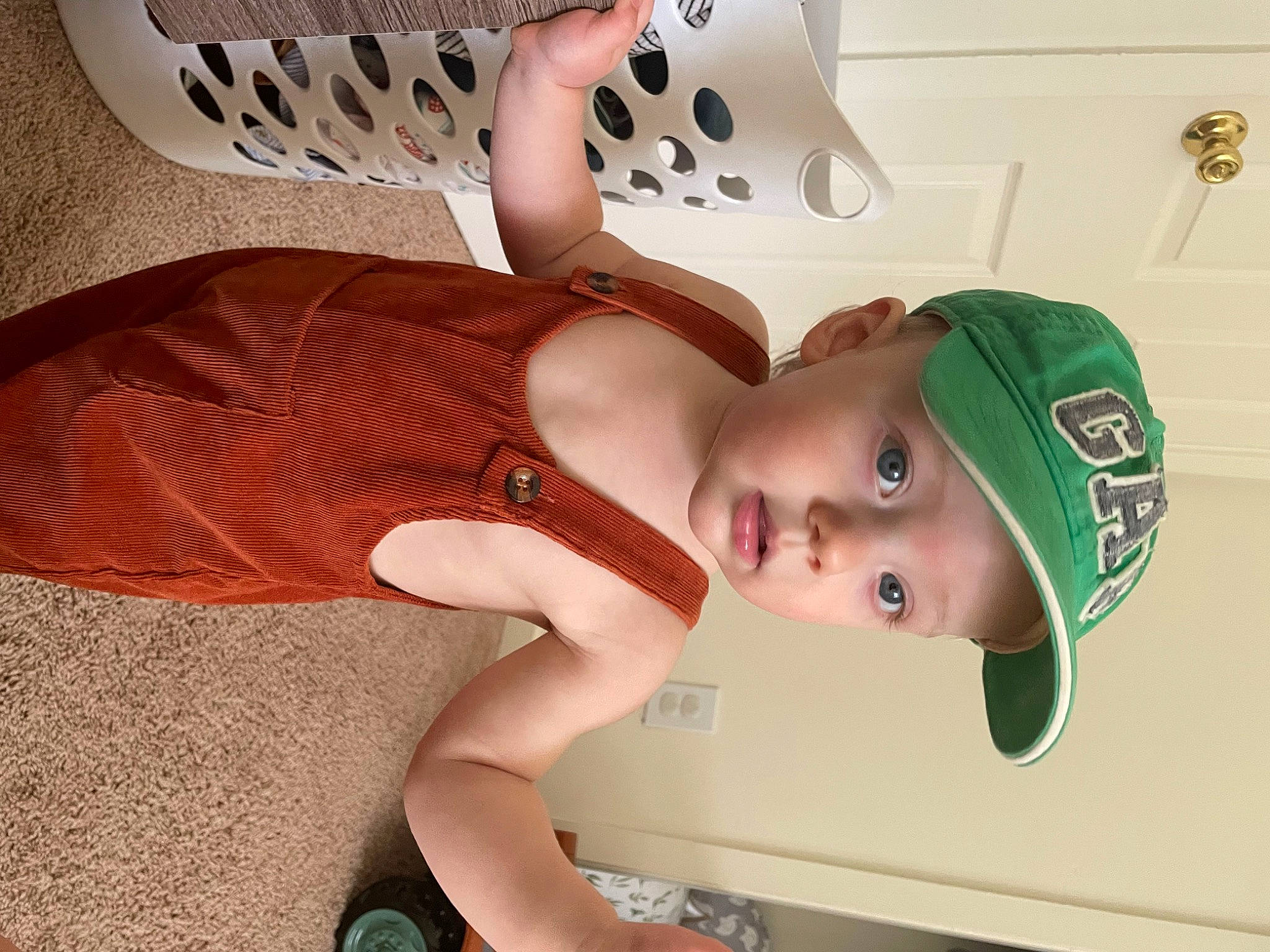 Cruz is registered to the contest to win money with this photo: baby_toddler_clothing, baseball_cap, cap, chest, comfort, elbow, eyelash, fashion_accessory, hand, hat, headwear, human_leg, joint, knee, neck, person, sandal, skin, sleeve, thigh