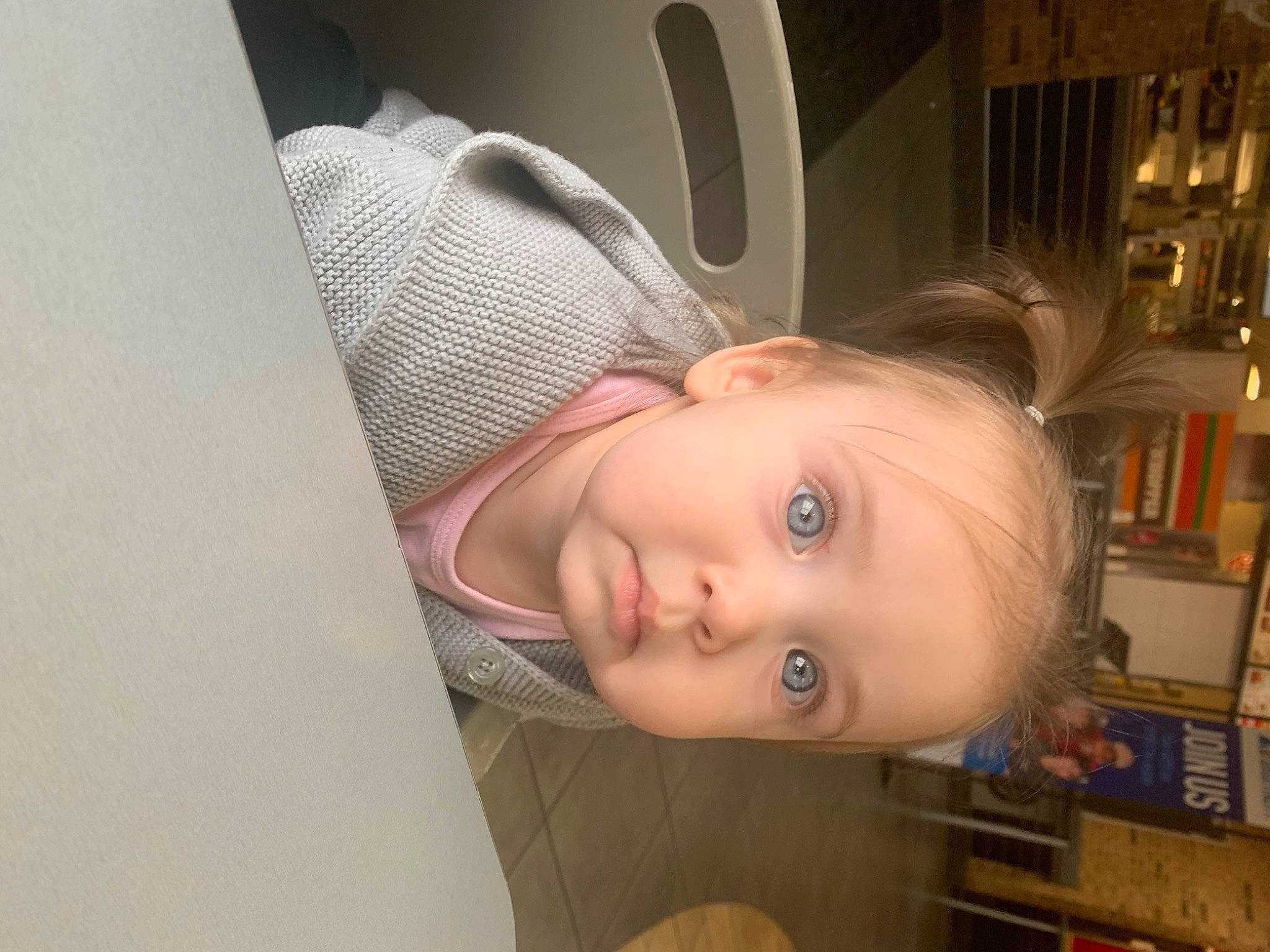 Grace is registered to the contest to win money with this photo: baby, baby_toddler_clothing, bookcase, cheek, child, comfort, ear, eyebrow, eyelash, flooring, fun, hardwood, iris, nose, person, room, shelf, skin, smile, toddler