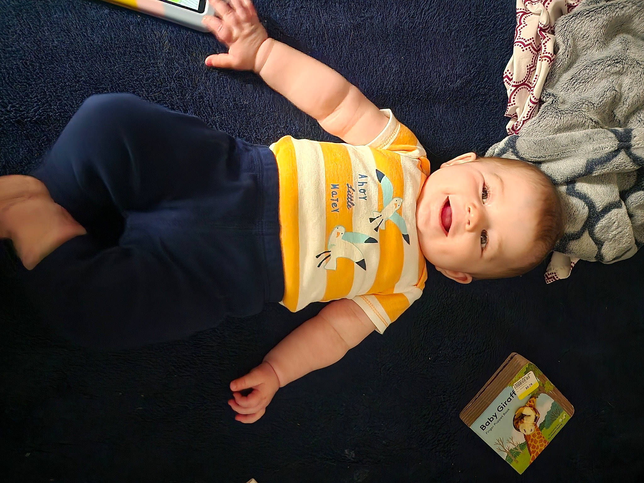 Jaxon is registered to the contest to win money with this photo: arm, baby, baby_products, baby_toddler_clothing, child, comfort, elbow, flooring, fun, gesture, happy, hat, knee, person, sitting, sleeve, smile, thigh, toddler, wood