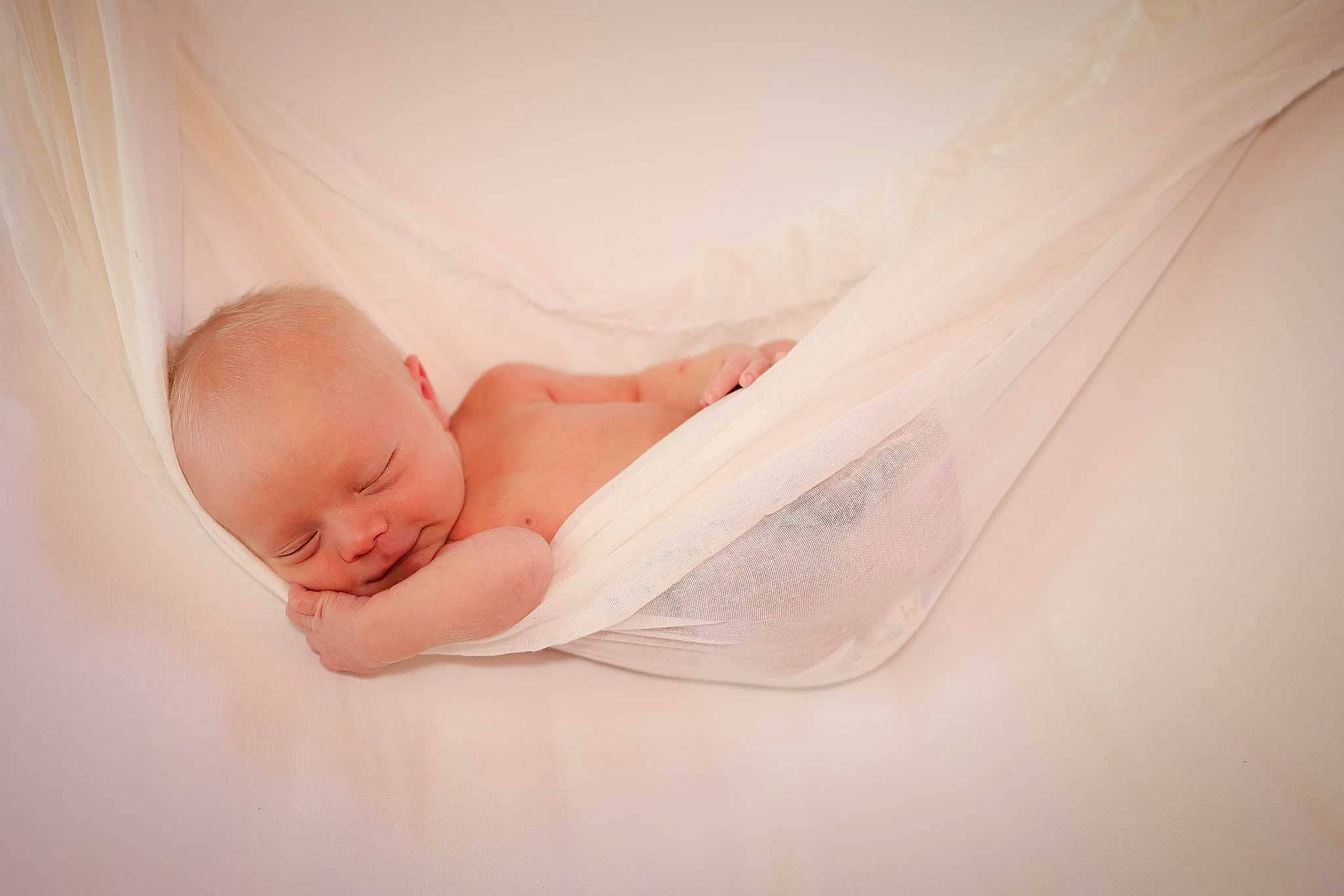 Willard is registered to the contest to win money with this photo: arm, baby, baby_toddler_clothing, bedding, child, comfort, elbow, finger, flash_photography, foot, hand, human_body, human_leg, leg, linens, peach, person, room, sitting, skin
