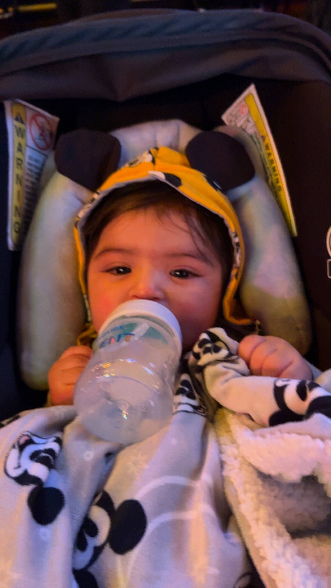 Martin is registered to the contest to win money with this photo: audio_equipment, baby, bottle, cheek, child, drinkware, event, eye, eyelash, facial_expression, finger, fun, head, mouth, nail, person, personal_protective_equipment, plastic_bottle, skin, toddler