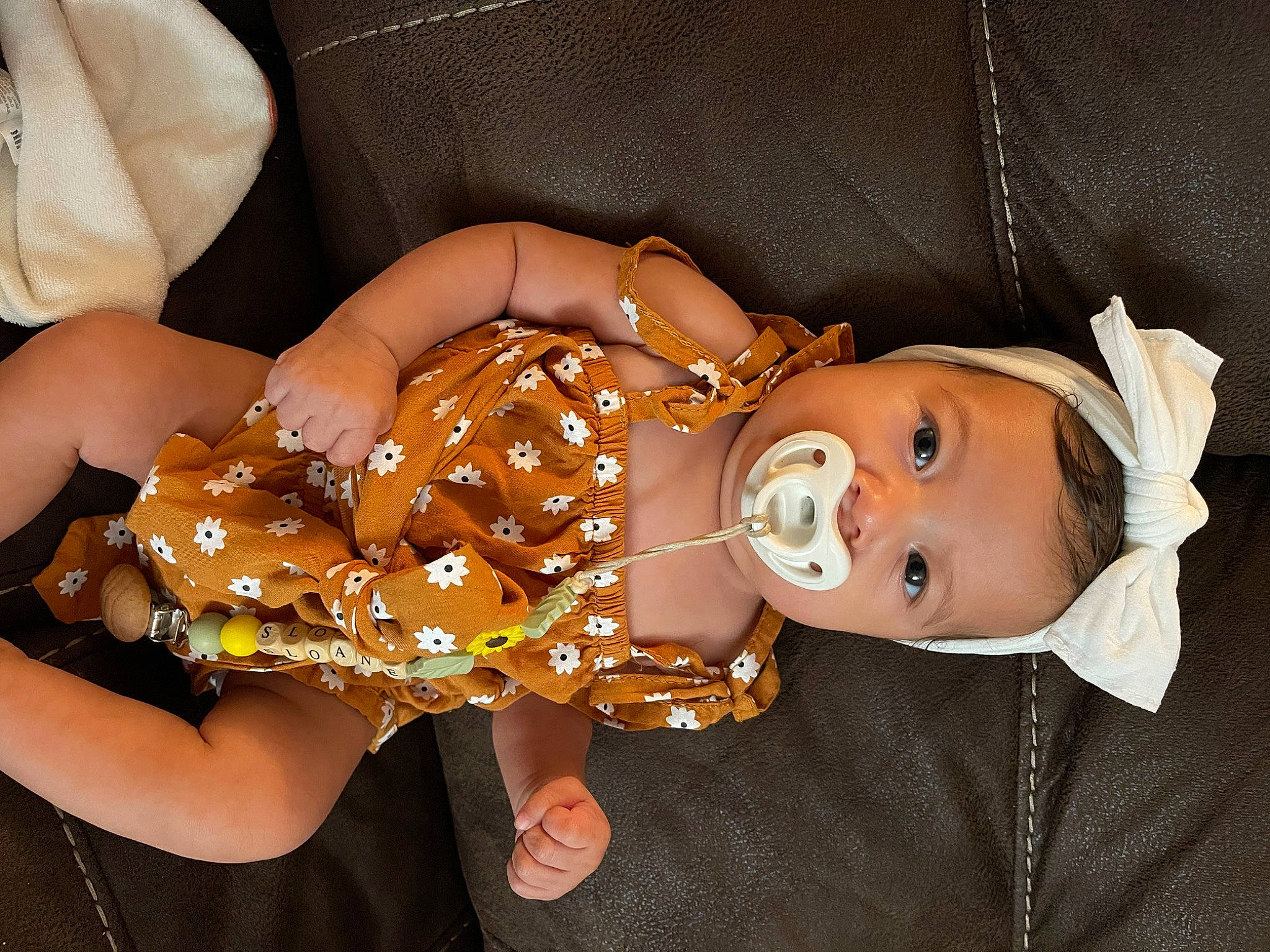 Sloane is registered to the contest to win money with this photo: baby, baby_toddler_clothing, child, costume_hat, doll, fashion_accessory, fun, gesture, happy, hat, human_leg, nail, orange, pattern, person, sleeve, thigh, thumb, toddler, toy