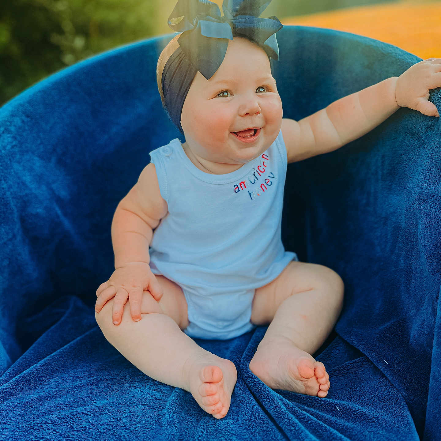 Laney joined the competition — help win amazing prizes! accessories, baby, babylaughing, blanket, clothing, diaper, dress, face, furniture, happy, head, jeans, laughing, pants, person, photography, portrait, sitting, smile, t_shirt
