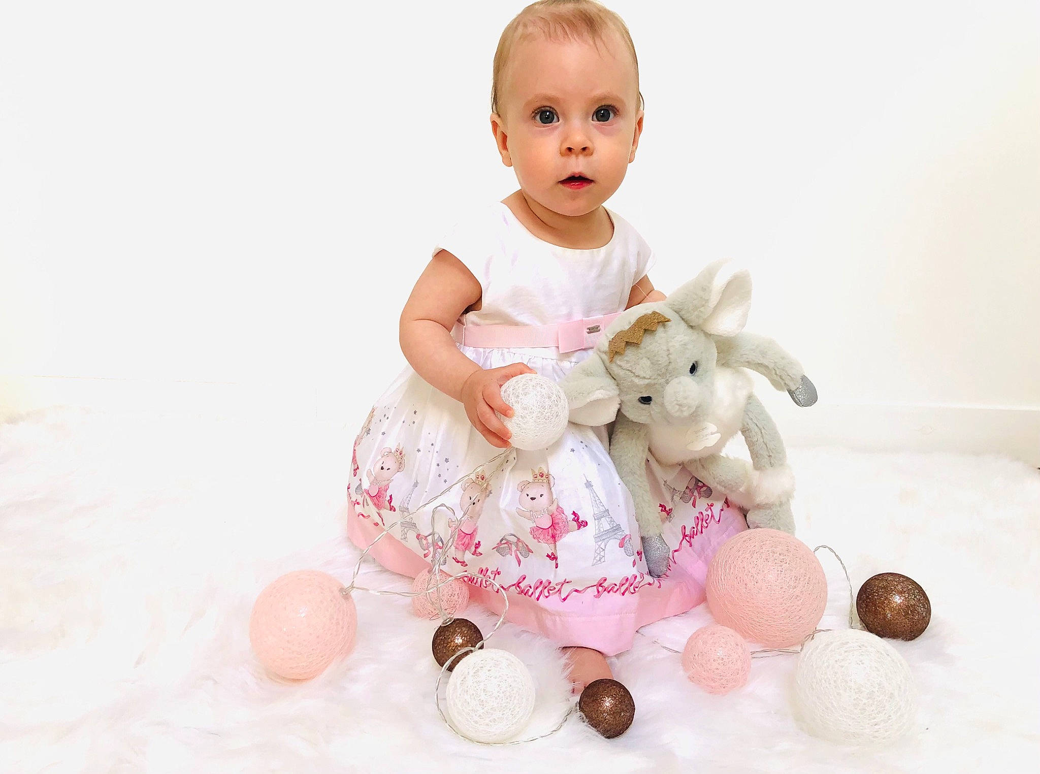 Thea participe au concours pour gagner de l'argent avec cette photo : baby, baby_products, baby_toddler_clothing, baby_toys, child, event, facial_expression, fun, happy, party_supply, pattern, person, pink, play, product, sitting, skin, sleeve, surprise, toddler