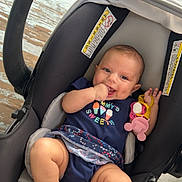Gabriella joined the competition — help win amazing prizes! baby, baby_girl, bare_feet, car_seat, casual, child, comfort, cute, happy, holding_toy, indoors, infant, navy_blue_clothing, person, playful, seatbelt, smiling, teething, toy, wooden_floor
