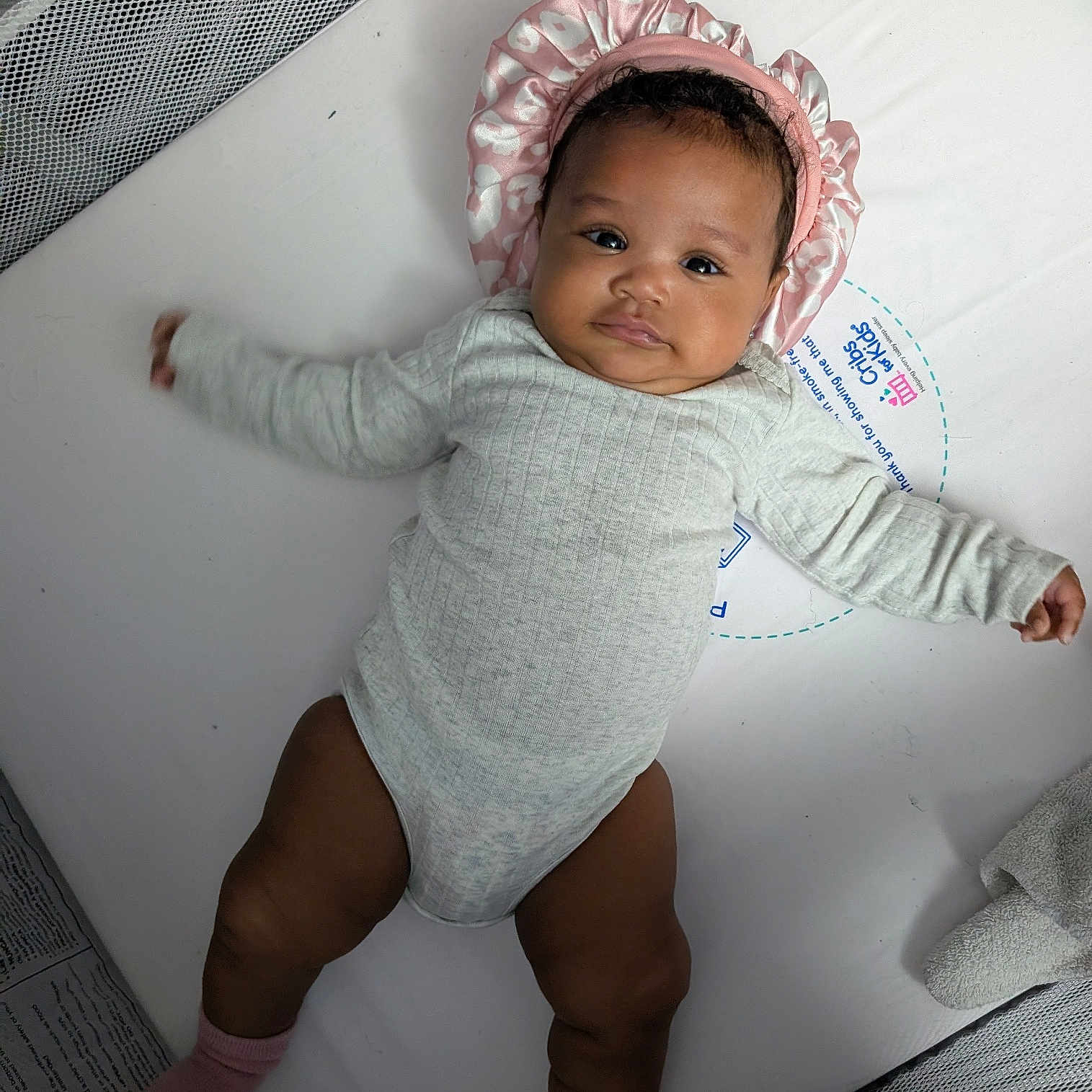 Raiya is registered to the contest to win money with this photo: baby, bodypart, bonnet, cap, clothing, face, finger, furniture, hand, hat, head, hosiery, knitwear, longsleeve, person, photography, portrait, sleeve, sock, sweater