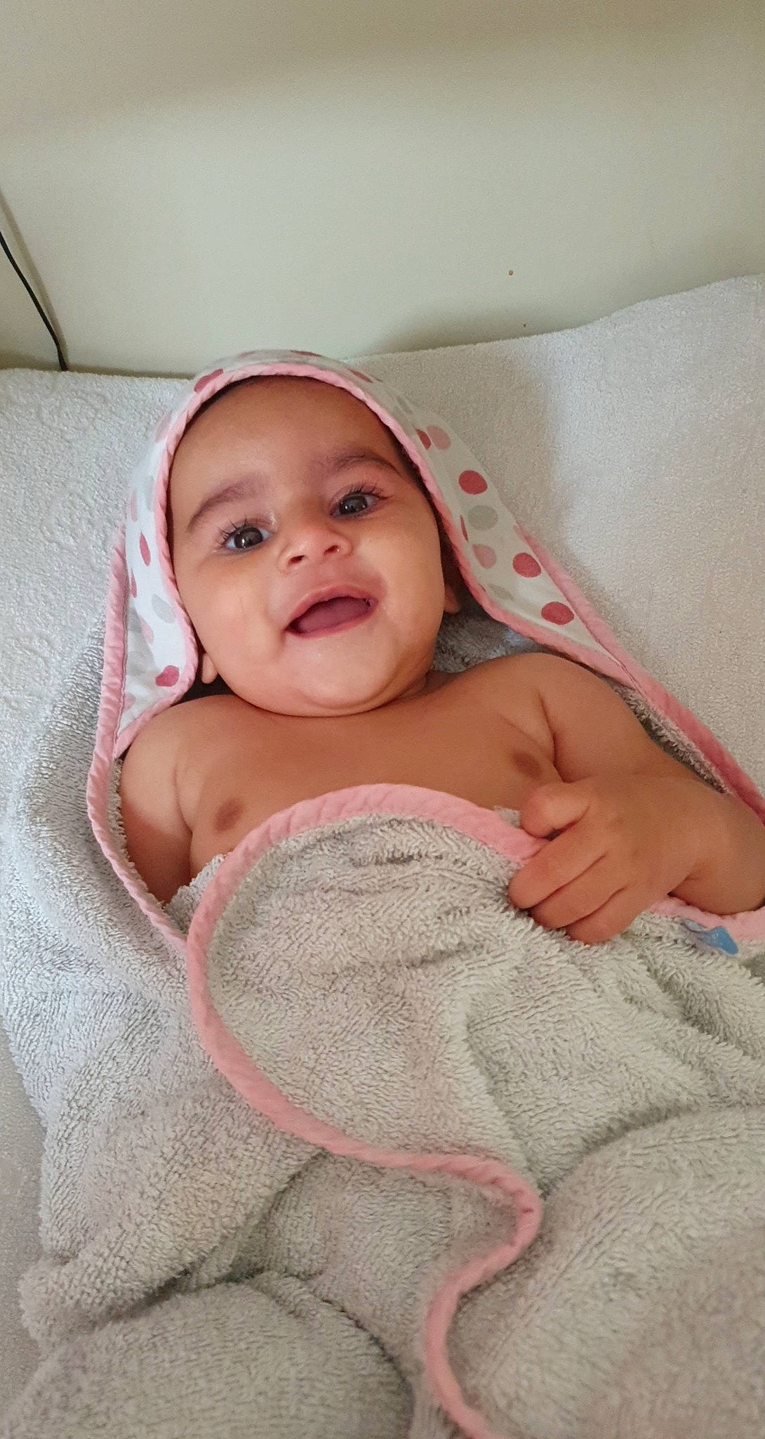 Inaya participe au concours pour gagner de l'argent avec cette photo : baby, baby_products, baby_toddler_clothing, bedding, blanket, cheek, child, comfort, flesh, headwear, linens, mouth, nose, person, pink, skin, textile, toddler, tongue, towel
