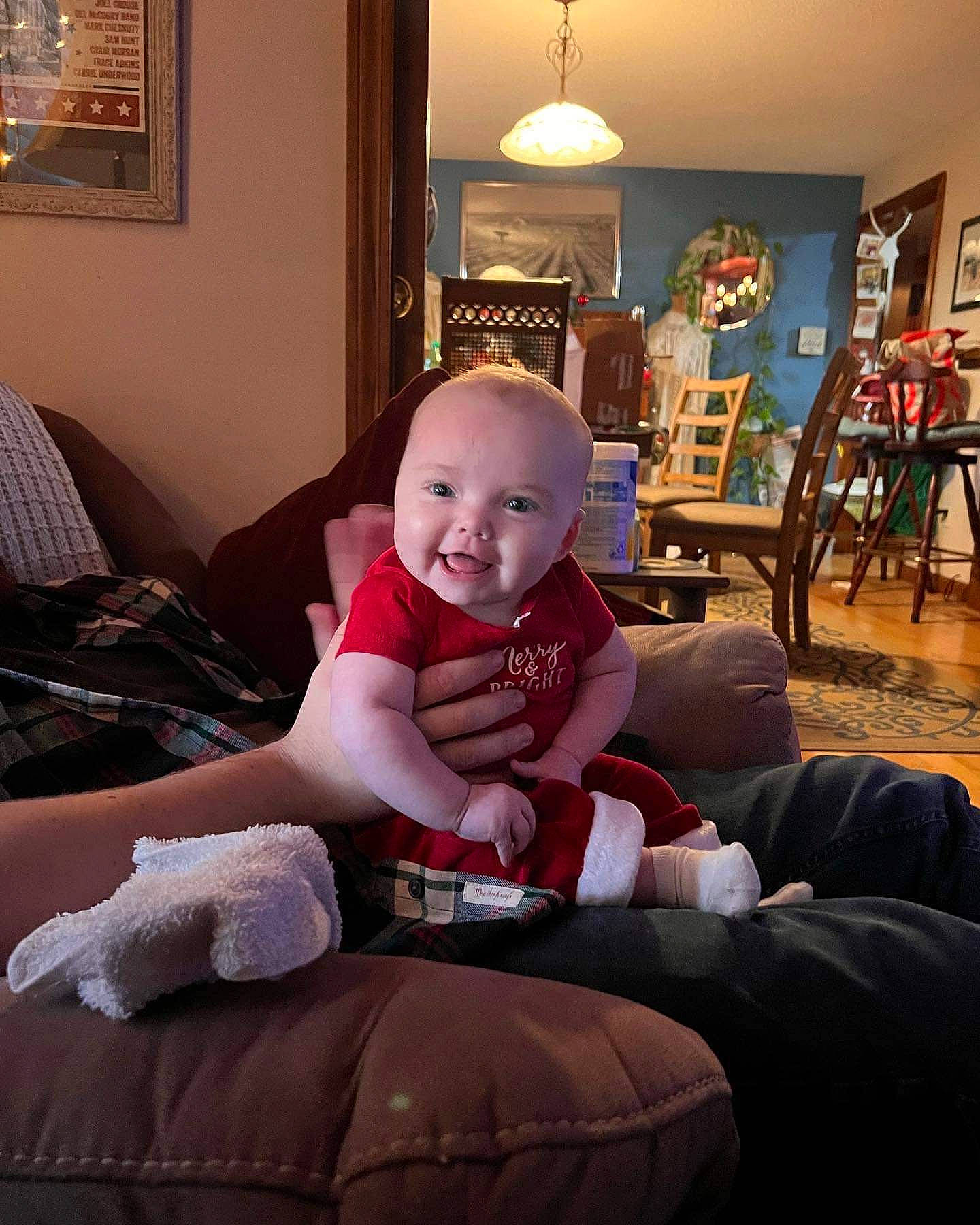 June joined the competition — help win amazing prizes! baby, baby_toddler_clothing, chair, child, comfort, couch, flooring, fun, happy, human_leg, knee, lamp, lap, living_room, person, picture_frame, room, sitting, smile, toddler