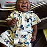 Hunter is registered to the contest to win money with this photo: baby, child, smiling, mickey_mouse, donald_duck, clothing, pillow, striped, sitting, happy, cute, infant, portrait, indoors, fabric, buttoned_shirt, shorts, person, young_child, relaxed